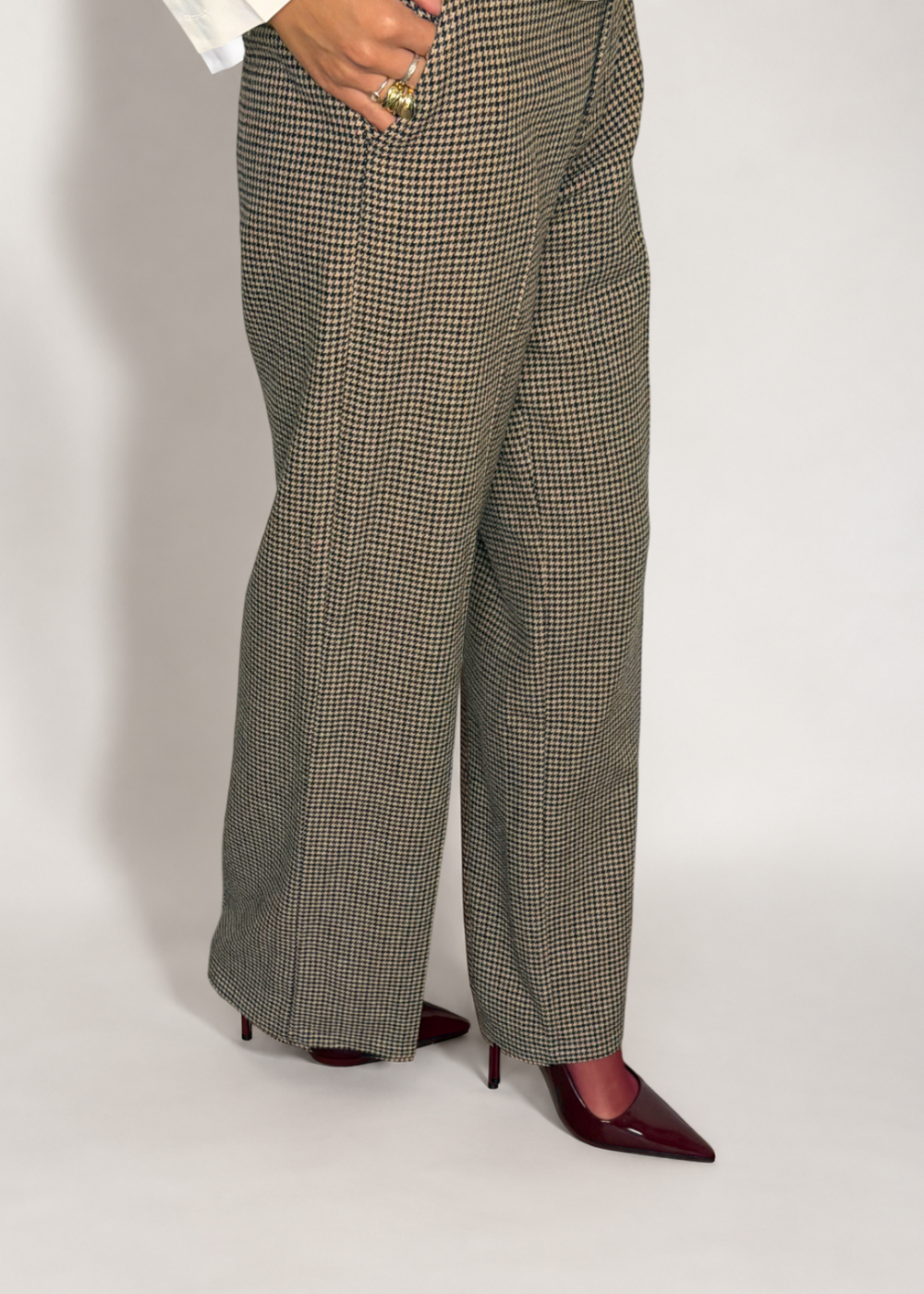 Angled view of the Brock trousers showing the houndstooth pattern and subtly flared hems